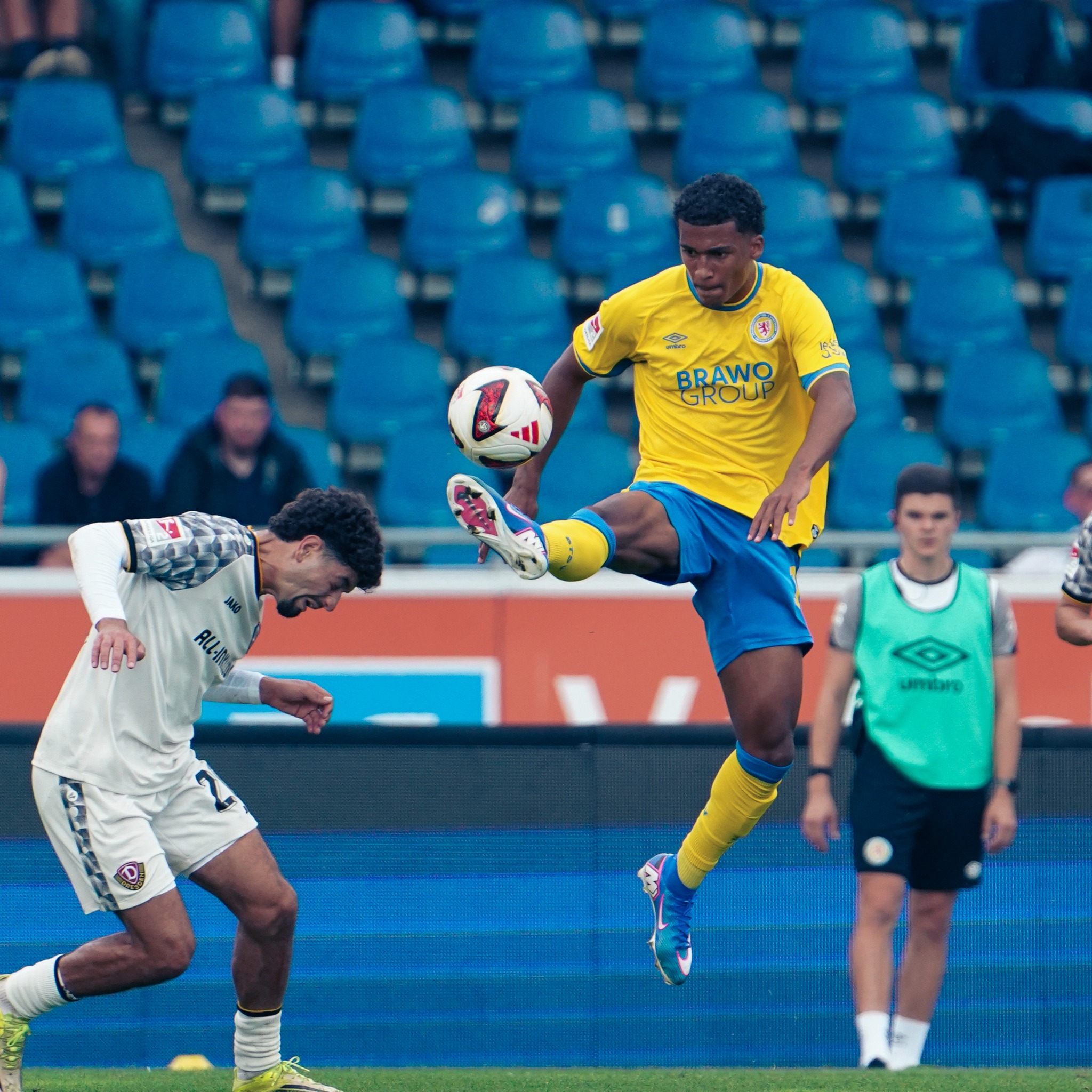 An Eintracht Braunschweig player leaps over a Dynamo Dresden challenge during the 2. Bundesliga match in Braunschweig.